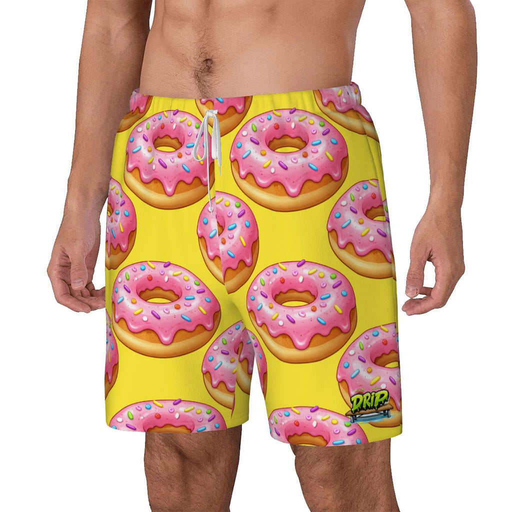 Yellow swim shorts with pink donut pattern on a white background