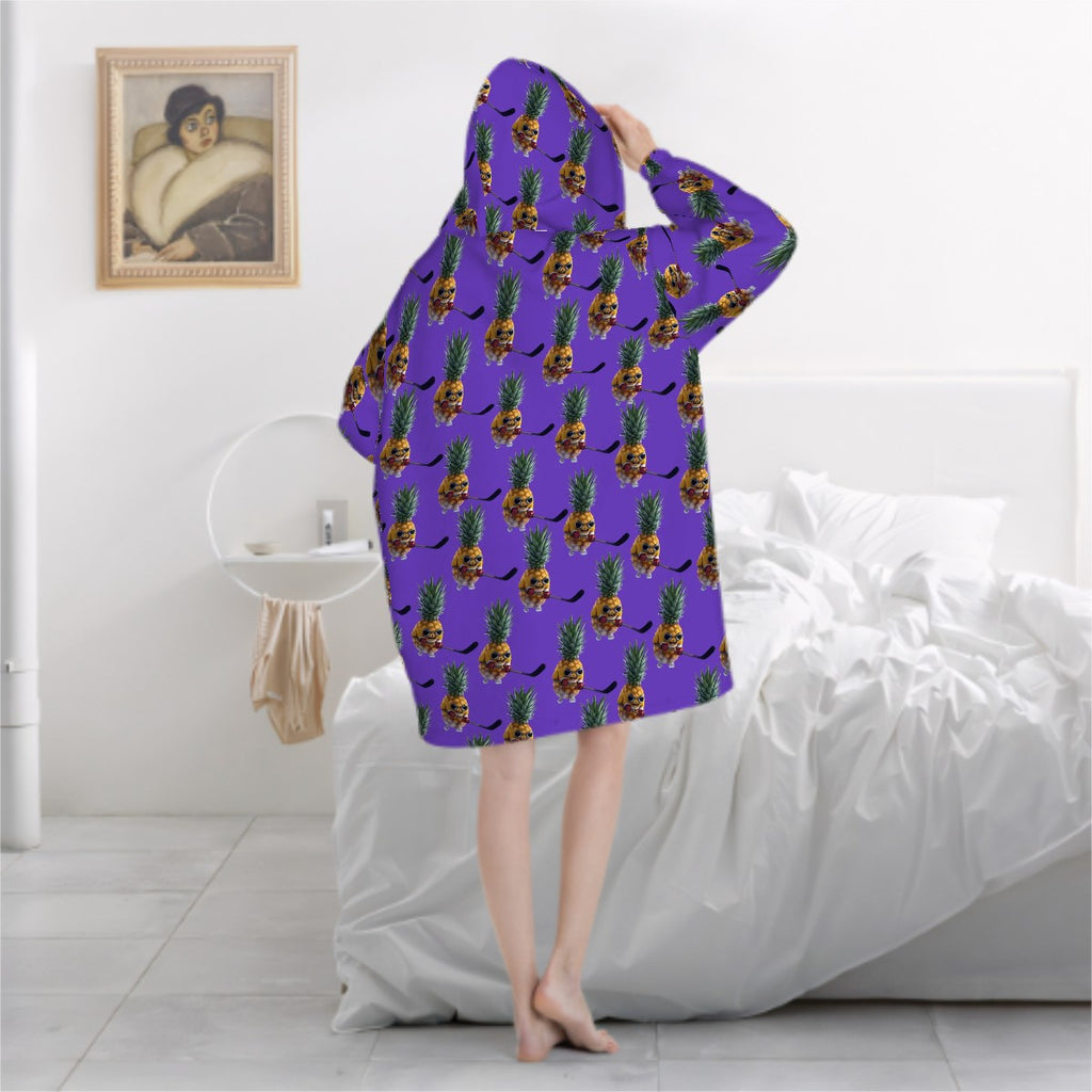 Person wearing a purple hoodie with pineapple pattern in a bedroom setting